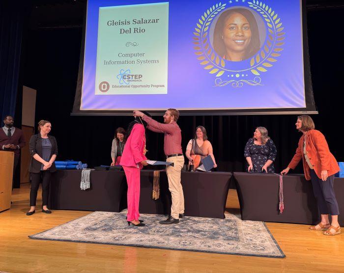 Graduating student Gleisis Salazar Del Rio receives her Educational Opportunity Program cord from Student Navigator Hunter Overstreet during the opportunity program's graduation celebration.