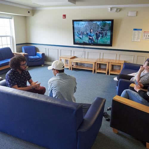 Students watching a show in the floor lounge