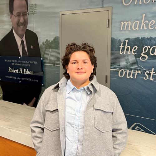 Giuliana Portolesi came to OCC from Spokane, Washington to play goalie on the Women's Lacrosse team and is this year's Rob Edson Scholarship recipient. She's pictured in front of a wall dedicated to Edson.
