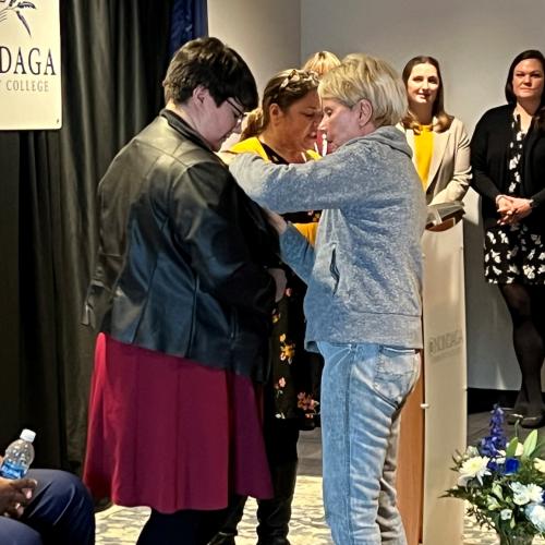 Gabriella Argiro (left) receives her Nursing pin from her grandmother Lynore Constantine (right) during the Nurse Pinning Ceremony December 14 in the Otis Suite.