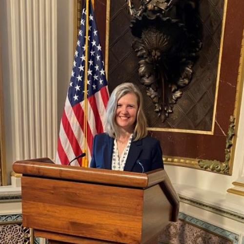 Onondaga Community College Provost and Senior Vice President Anastasia Urtz poses for a picture at a podium in the Eisenhower Building before speaking at the White House.