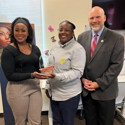 Shawni Davis (center) receives New York State Small Business Development Center's 2023 Minority Entrepreneur of the Year Award from Sonya Smith (left) of the NYS SBDC and Bob Griffin of the SBDC office headquartered at OCC (right).