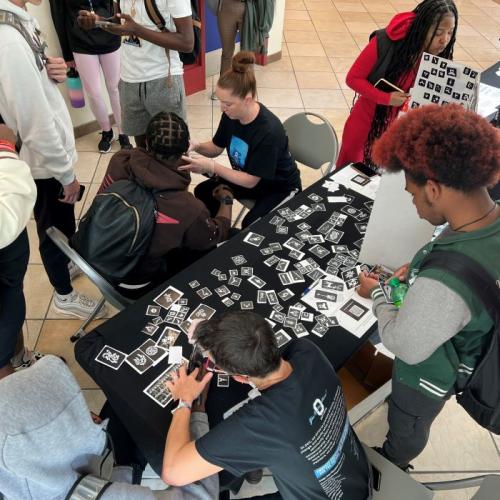 OCC's Shannon Nolan (upper center wearing black t-shirt) and Colleen Stevens (lower center wearing black t-shirt) apply henna tattoos on students arms during Unity Day festivities.