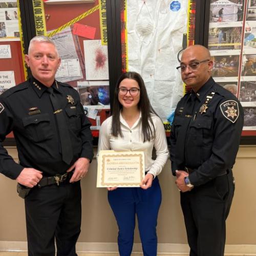 OCC Criminal Justice major Daniela Arevalo-Leyva (center) is presented with a scholarship from Onondaga County Sheriff Toby Shelley (left) and Lieutenant Crayg Dykes (right).