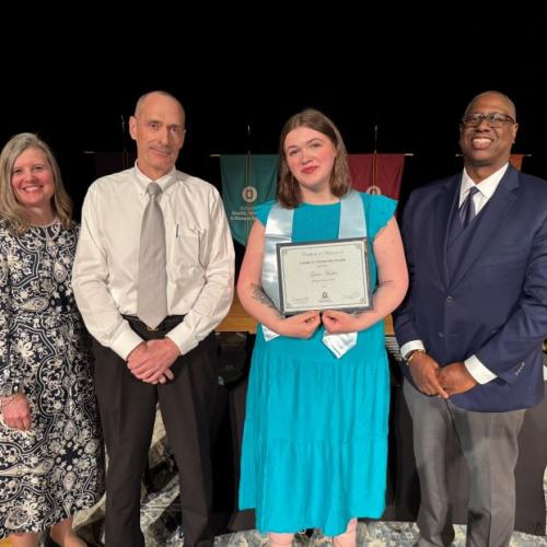 Grace Meeker (holding certificate) was named Curriculum Honoree in the Business Administration degree program. She's pictured with (left to right) Provost Anastasia Urtz, Professor JT Ryan, and President Warren Hilton.