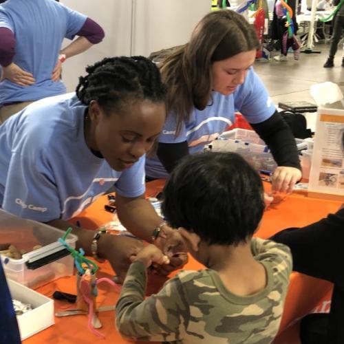 OCC students (left to right) Irielle Mwija and Sarah Raymond helped Maker Faire Syracuse attendees make wigglebots.