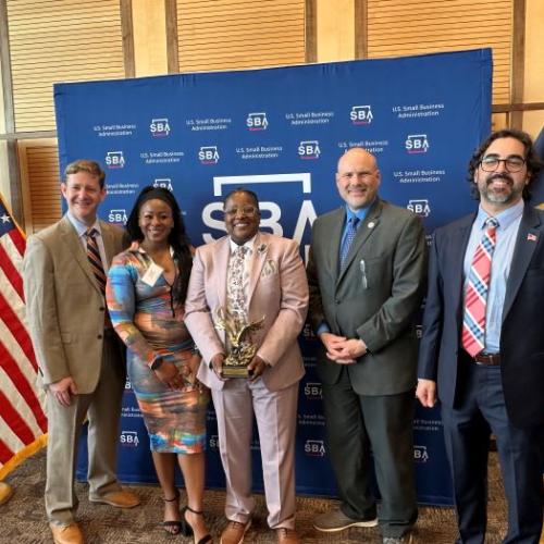 Shawni Davis (center) of Luminary Electrical receives the Small Business Administration's Small Business Person of the Year Award.