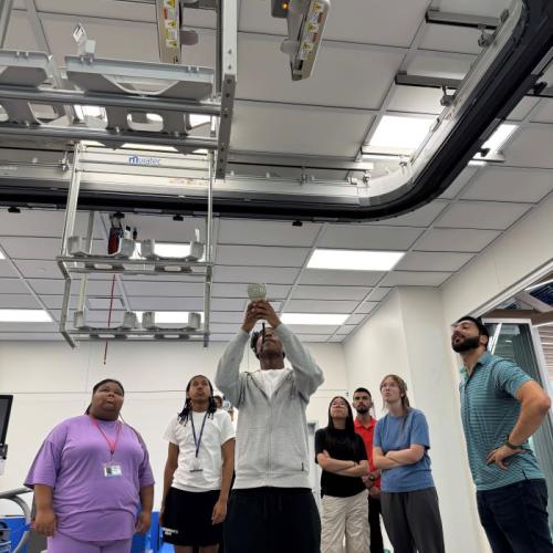 Students in the Pre-College Semiconductor Summer Program experiment with the robotics in the new Micron Cleanroom Simulation Lab on the Onondaga Community College campus.