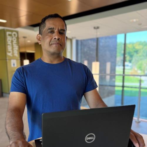 Justin Tani is a 48-year-old student in Onondaga Community College's Cybersecurity degree program. He's pictured in Coulter Library.