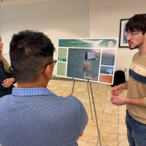 Nicholas Pangaro (right) discusses his research experience during a symposium in the Storer Auditorium Lobby. Pangaro is a Laboratory Sciences major who conducted research at SUNY-ESF during the summer.