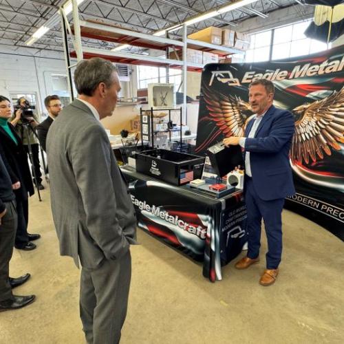 Michael Bower (right), a United States Marine Corps Veteran and owner of Eagle Metalcraft, shows one of the products his company makes.