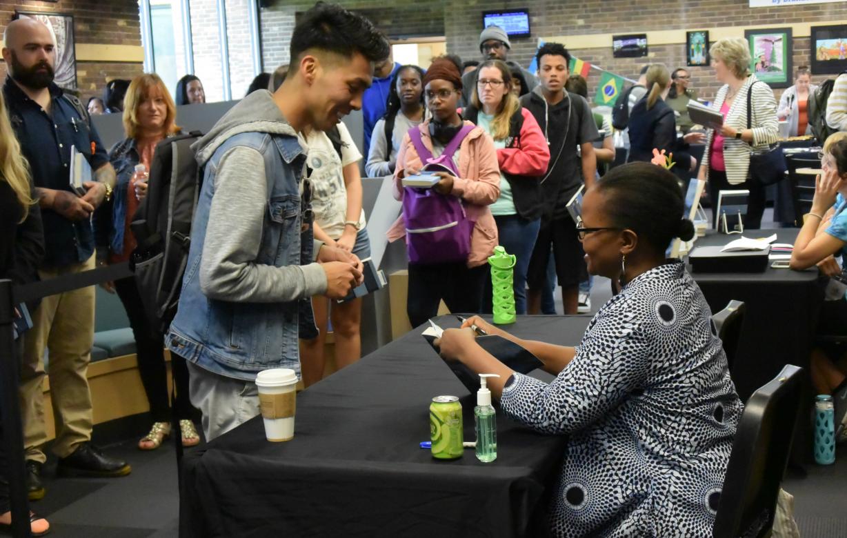 photo of students getting their book autographed by Edwidge Danticat
