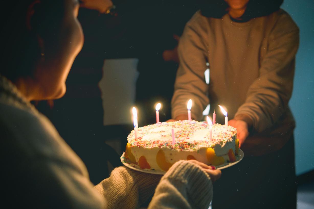 Woman with a birthday cake blowing out candles