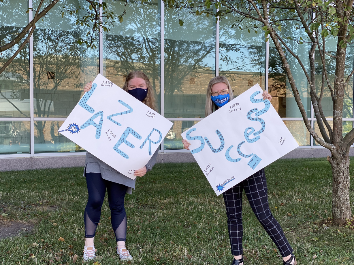 Student & Employee with Lazer Success Signs Student & Employee with Lazer Success Signs