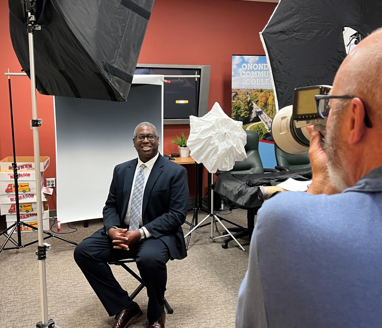 Dr. Warren Hilton poses for his official headshot photo. Taking his picture is photographer Chuck Wainwright.