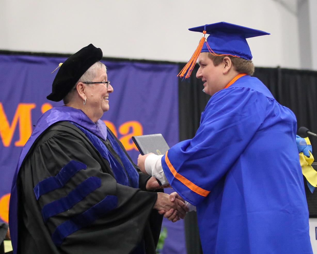 OCC President Dr. Casey Crabill (left) presents an associate degree to Caleb Jandolenko, a member of East Syracuse Minoa's class of 2022. Jandolenko was one of 17 students who received his high school diploma and college degree on the same day. OCC President Dr. Casey Crabill (left) presents an associate degree to Caleb Jandolenko, a member of East Syracuse Minoa's class of 2022. Jandolenko was one of 17 students who received his high school diploma and college degree on the same day.