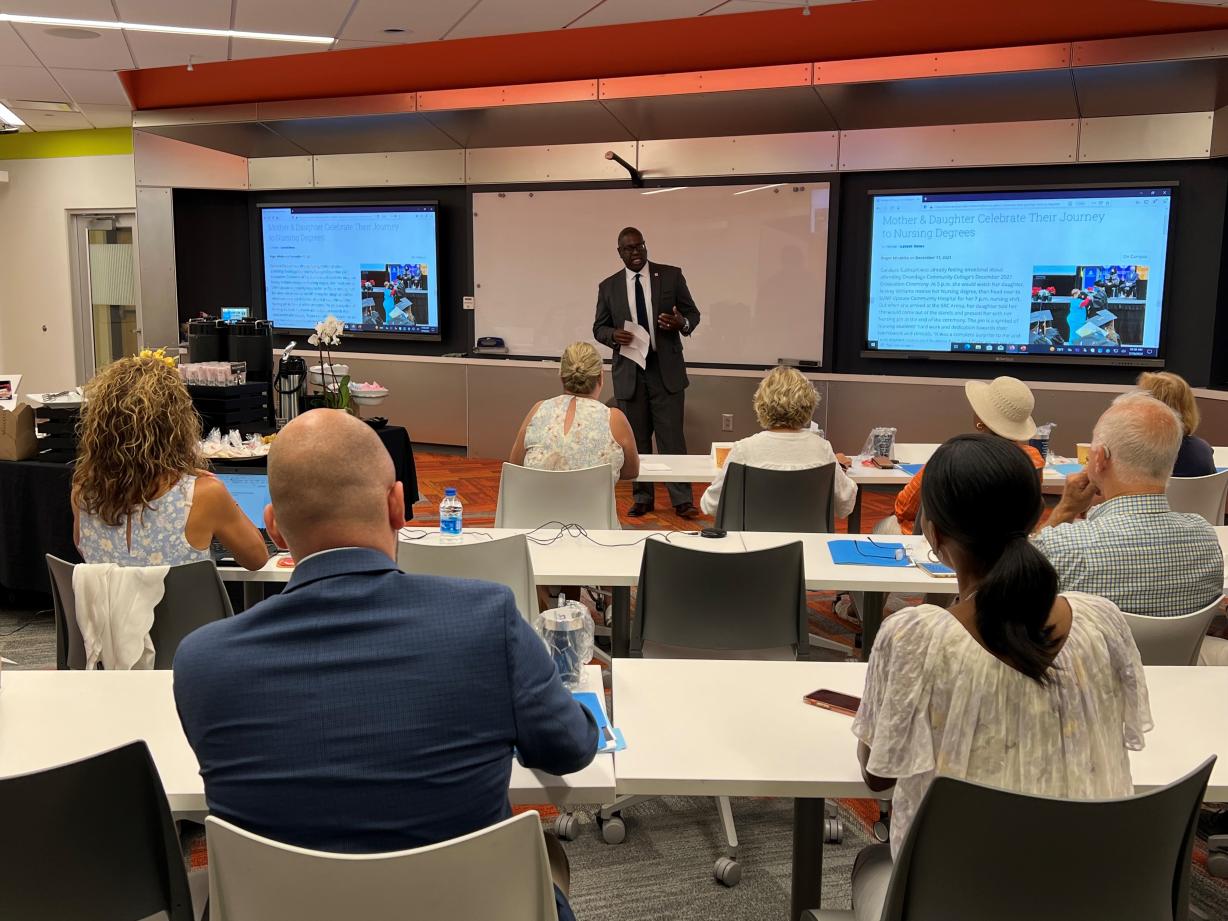 OCC President Dr. Warren Hilton (standing) speaks with members of the Onondaga County Legislature's Health and Human Services Committee and Facilities Committee during a meeting in Ferrante Hall.