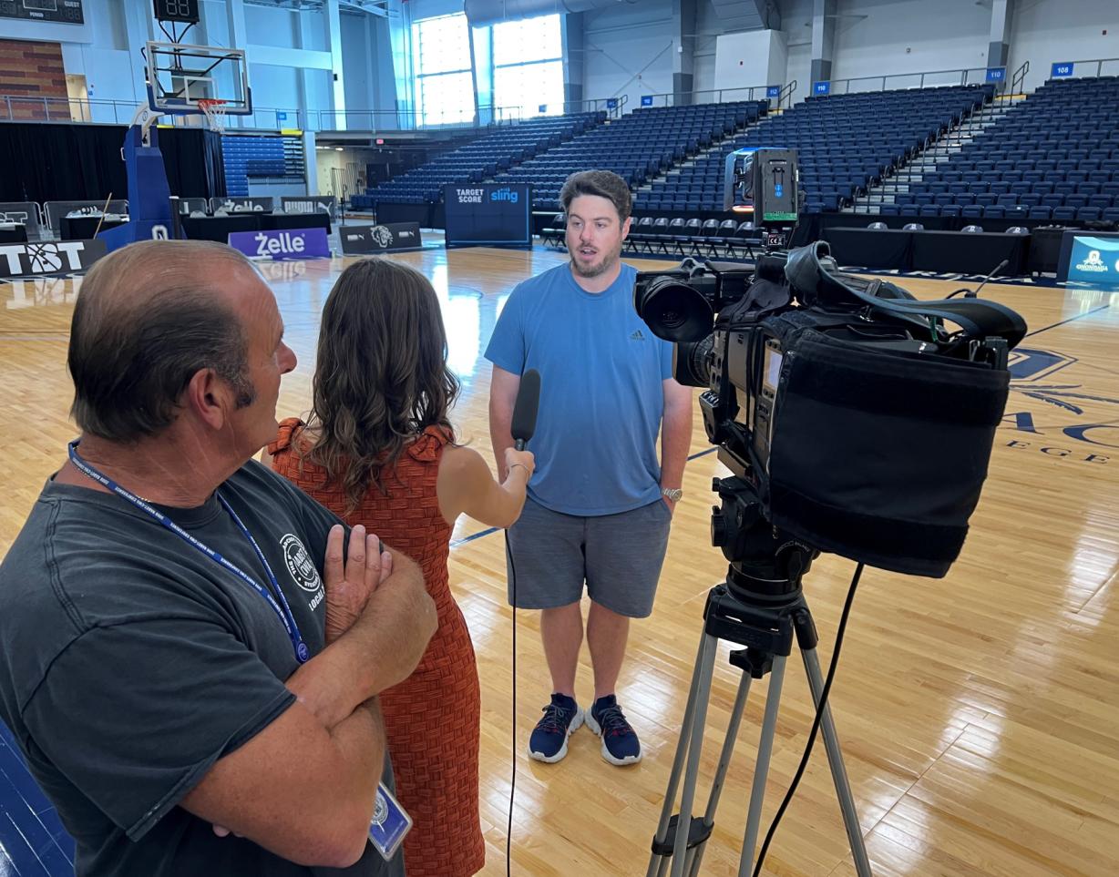 Charles Grant '03 tells WSYR TV Newschannel 9 reporter Isabella Colello and photographer Anthony Vecchio about his busy schedule. He'll be operating a live camera at both TBT in SRC Arena and the Baseball Hall of Fame Induction Ceremonies in Cooperstown.