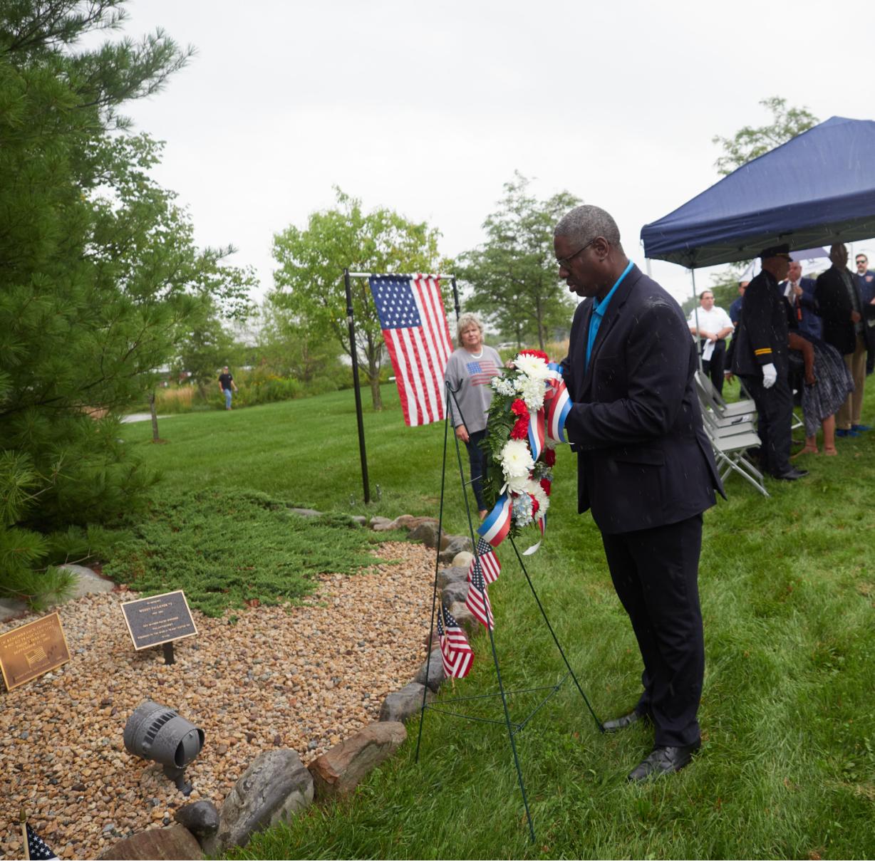 OCC President Dr. Warren Hilton places a wreath at the college's 9/11 memorial outside the Whitney Applied Technology Center.