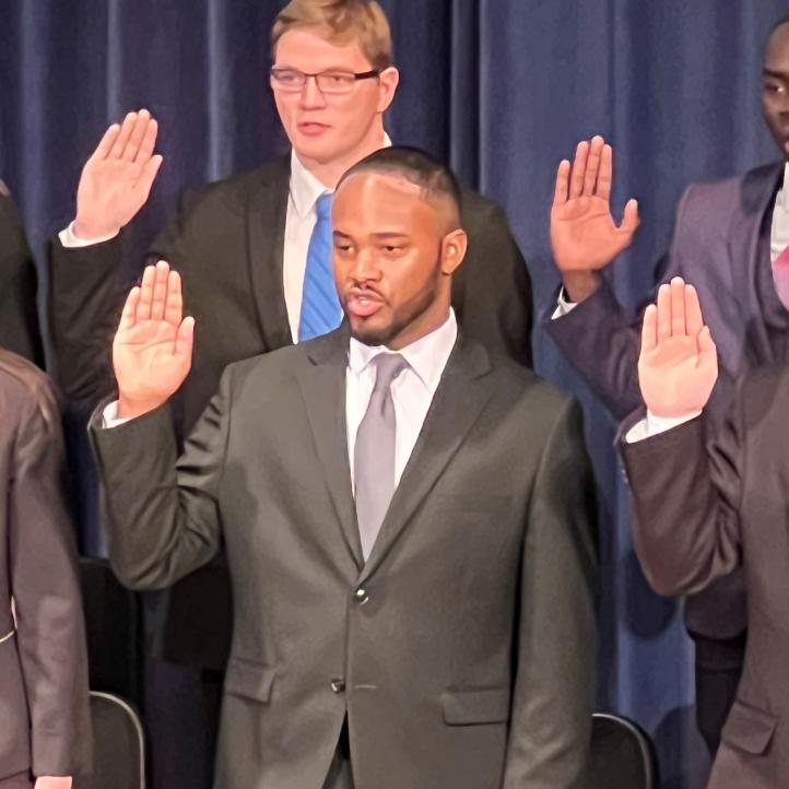 DeJuan Tigner Jr. (front row, center) was sworn-in as a Syracuse Police Officer during a ceremony in Storer Auditorium. Tigner is a 2022 graduate of OCC's Criminal Justice degree program.