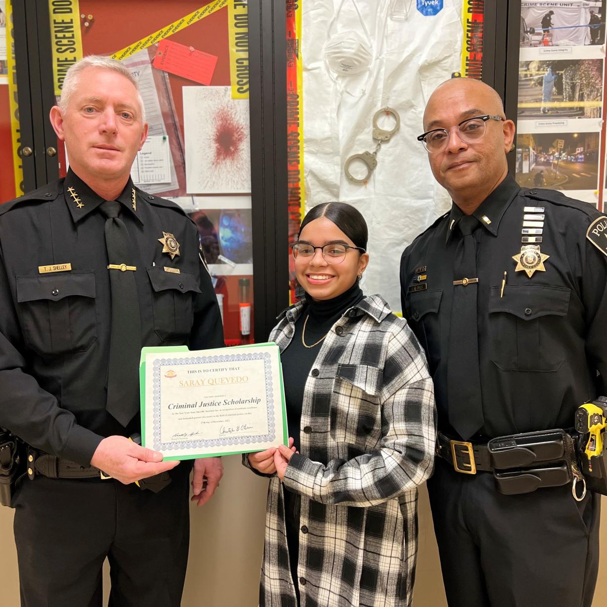 Saray Quevedo (center) receives her Criminal Justice Scholarship from Onondaga County Sheriff Toby Shelley (left) and Crayg Dykes (right). Saray Quevedo (center) receives her Criminal Justice Scholarship from Onondaga County Sheriff Toby Shelley (left) and Crayg Dykes (right).