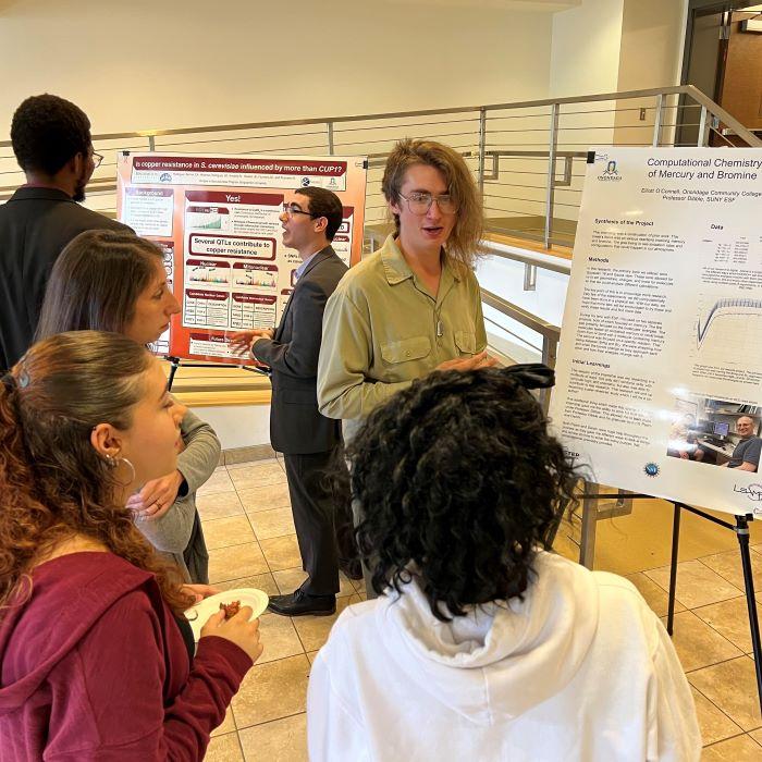 OCC students Carlos Rodriguez-Bornot (center left) and Elliott O'Connell (center right) discuss their summer research experiences during the Science Symposium.