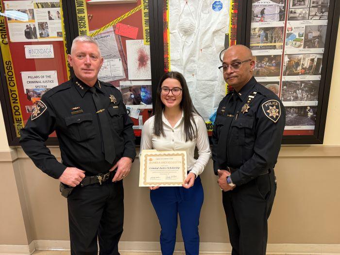 OCC Criminal Justice major Daniela Arevalo-Leyva (center) is presented with a scholarship from Onondaga County Sheriff Toby Shelley (left) and Lieutenant Crayg Dykes (right). OCC Criminal Justice major Daniela Arevalo-Leyva (center) is presented with a scholarship from Onondaga County Sheriff Toby Shelley (left) and Lieutenant Crayg Dykes (right).