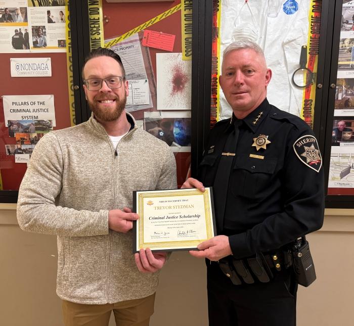 OCC Student Trevor Stedman receives the Criminal Justice Scholarship from Onondaga County Sheriff Toby Shelley.