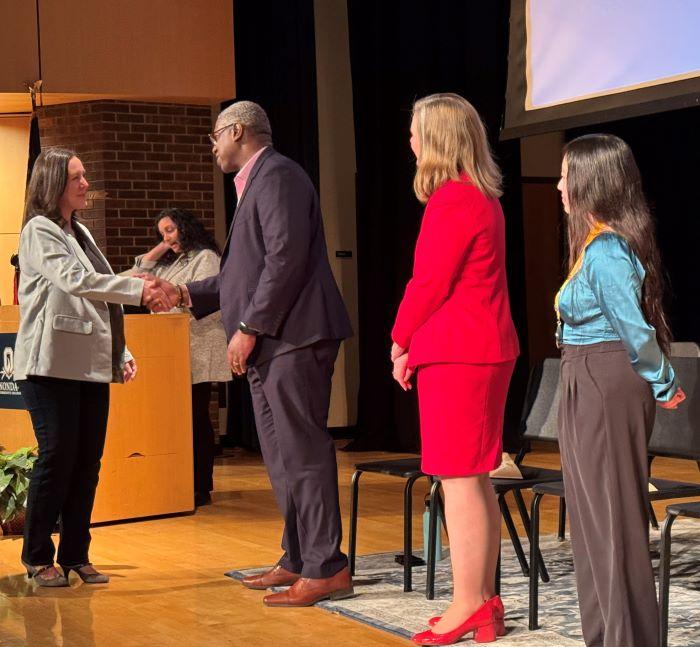 OCC student Katie Morgan (left) shakes hands with OCC President Dr. Warren Hilton as she is inducted into the PTK Honor Society. Morgan is a mother of three daughters, all of whom graduated from OCC.