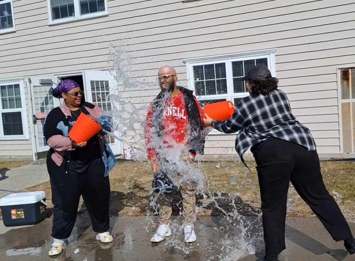 Residence Hall Director Keven Carlo gets drenched by two students during the "Splash for a Cause" event. Residence Hall Director Keven Carlo gets drenched by two students during the "Splash for a Cause" event.