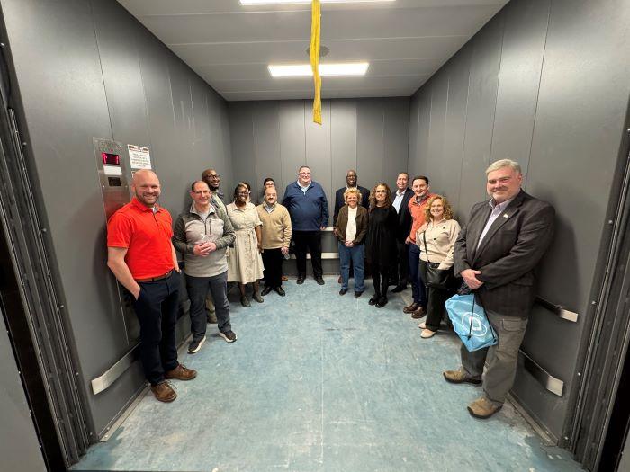 Members of the Onondaga County Legislature's Facilities Committee take a ride up the new freight elevator as they tour construction in the Whitney Applied Technology Center.