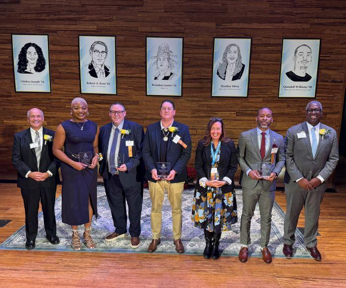 Left to right: event emcee Glenn LaPoint '16, Chidera Joseph '16, Rob Kent '82, Brandon Lazore '14, Heather Silvia '90, Quindell Williams '08, OCC President Dr. Warren Hilton. Left to right: event emcee Glenn LaPoint '16, Chidera Joseph '16, Rob Kent '82, Brandon Lazore '14, Heather Silvia '90, Quindell Williams '08, OCC President Dr. Warren Hilton.