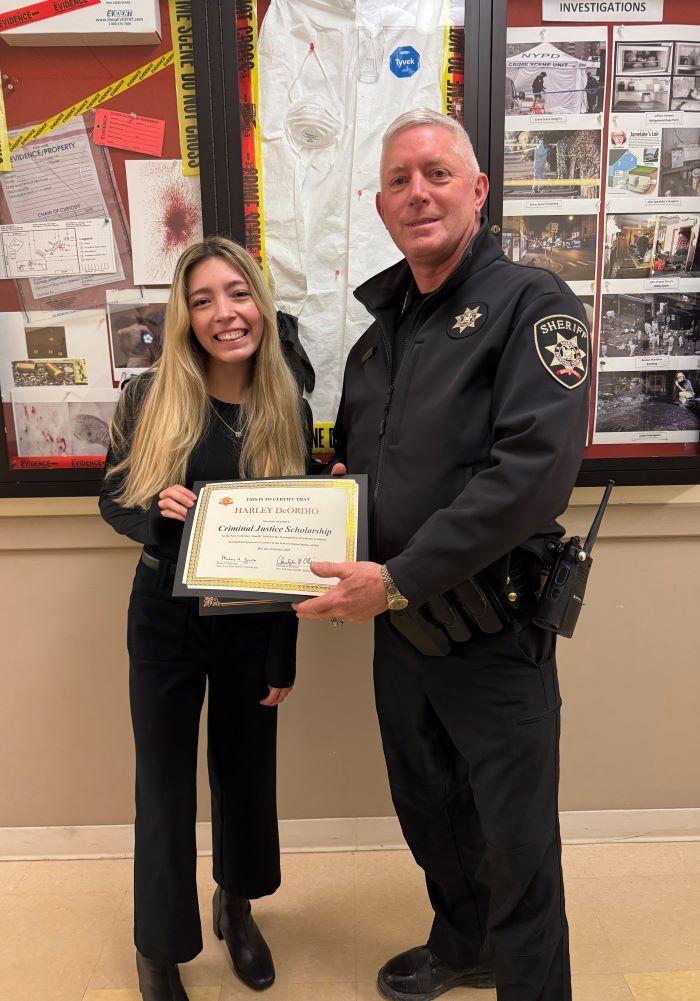 Harley DeOrdio is presented the New York Sheriff's Scholarship by Onondaga County Sheriff Toby Shelley. They are pictured in Ferrante Hall on the Onondaga Community College campus.