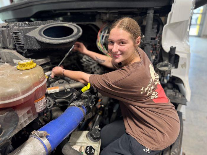 Alaina Kelsey is one of the top students in Onondaga Community College's Automotive Technology and Commercial/Heavy Equipment Service Repair degree programs. She's pictured working on a 2023 Freightliner in the College's new Commercial/Heavy Equipment Service Repair garage.