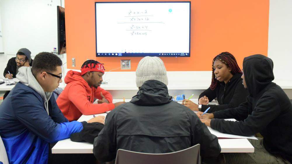 Students work together to solve a math problem in the new classroom on the second floor of Ferrante Hall.