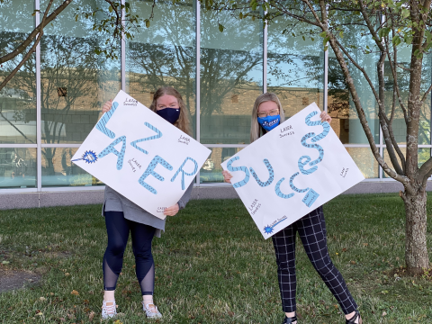 Student & Employee with Lazer Success Signs