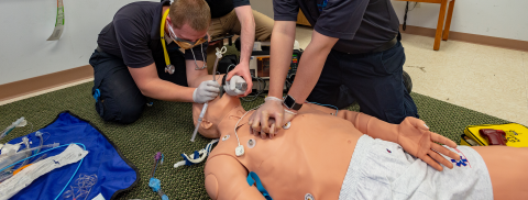Paramedic students practicing on a dummy
