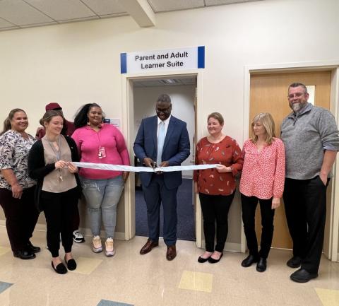 OCC President Dr. Warren Hilton (center) cuts the ribbon on the new Parent and Adult Learner Suite in Mawhinney Hall.