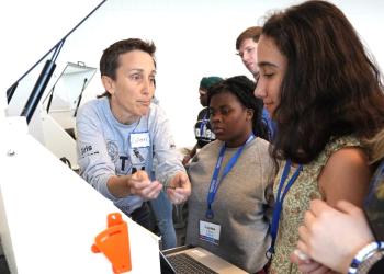 Colleen Stevens (left) works with students during a CNC Machining exercise as part of a Micron-Sponsored "Girls Going Tech" event at Onondaga Community College.